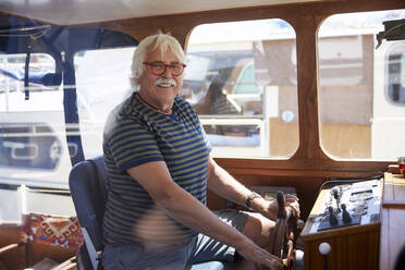 Senior man wearing eyeglasses sailing boat - RHF02647
