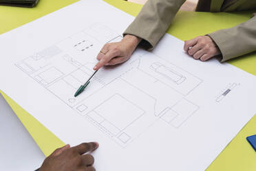 Architect explaining floor plan on table - PNAF04340