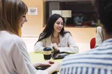 Businesswoman having a meeting with colleagues in office - PNAF04346