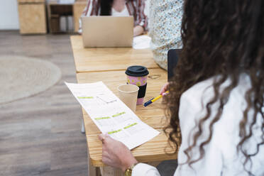 Businesswoman holding document in office - PNAF04406