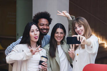 Playful business team taking a selfie in office - PNAF04431