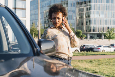 Geschäftsfrau, die am Auto stehend mit einem Mobiltelefon spricht - VPIF07023