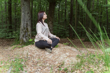 Young woman practicing yoga in forest - OSF00698