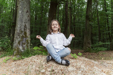 Happy girl with eyes closed meditating in forest - OSF00704