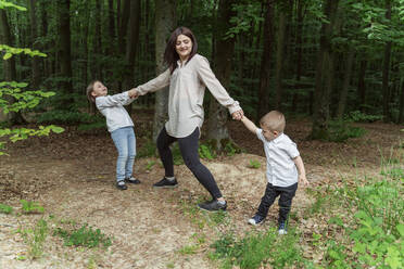 Mutter mit Sohn und Tochter spielen im Wald - OSF00705