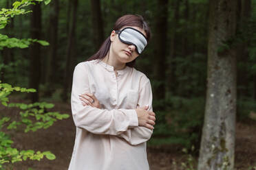 Frau stehend mit Schlafmaske im Wald - OSF00709