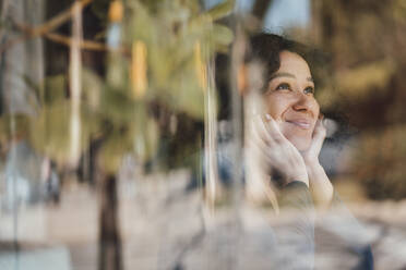 Lächelnde Frau durch Glas gesehen - JOSEF11864