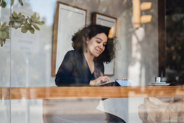 Frau mit Tablet-PC am Tisch in einem Café sitzend - JOSEF11867