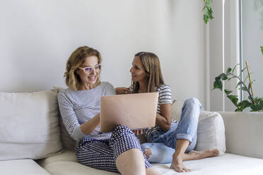 Homosexuelles Paar diskutiert über Laptop auf der Couch zu Hause - RFTF00283