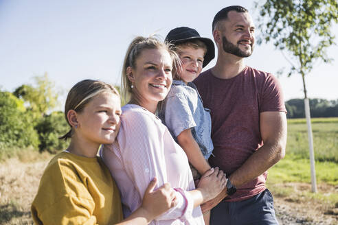 Confident family standing in nature looking at distance - UUF27100