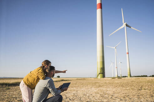 Familie benutzt digitales Tablet im Windpark - UUF27119