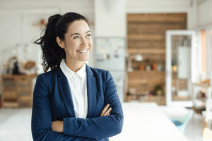 Happy businesswoman standing with arms crossed - JOSEF11932