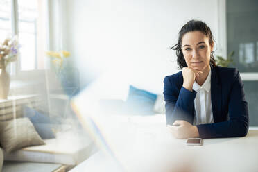 Businesswoman sitting with hand on chin - JOSEF11943