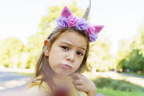 Girl wearing unicorn headband taking selfie at park - TOF00032