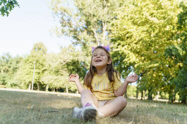 Cheerful girl sitting on grass at park - TOF00034