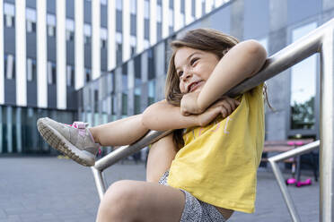 Playful girl climbing on railing at bicycle parking station - TOF00041