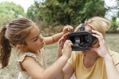 Mädchen passt Virtual-Reality-Simulator für Großmutter im Park an - TOF00051