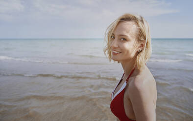 Happy woman at beach on sunny day - AZF00418