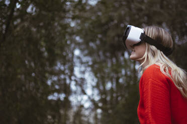 Woman wearing VR glasses in forest - AMWF00309