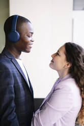 Young man standing face to face with woman - AMWF00339