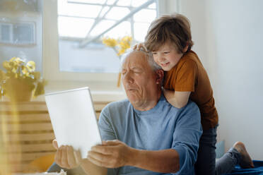 Grandfather taking selfie with grandson through tablet PC at home - JOSEF12102