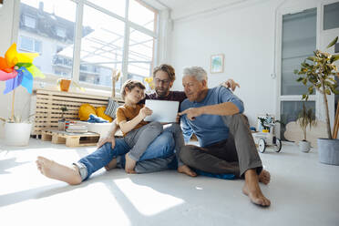 Junge teilt Tablet-PC mit Vater und Großvater zu Hause - JOSEF12126