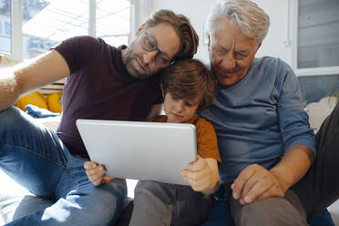 Multi-generation family watching movie on tablet PC at home - JOSEF12132
