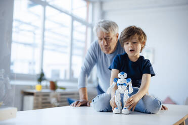 Boy with robot model by grandfather at home - JOSEF12157