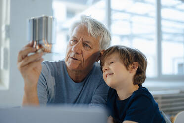 Älterer Mann mit Enkel bei der Analyse des Heizmoduls zu Hause - JOSEF12236