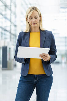 Blond mature businesswoman using tablet PC - DIGF18653