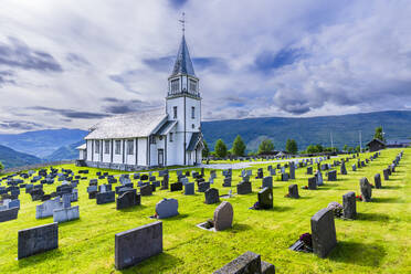 Norwegen, Viken, Gol, Reihen von Grabsteinen mit ländlicher Kirche im Hintergrund - STSF03455