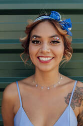 Smiling woman with headband and glittering eye make-up - PGF01214