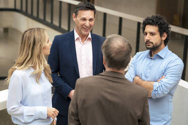 Business colleagues planning strategy together in corridor - JOSEF12483