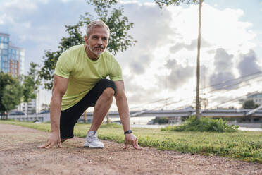 Mature man preparing for run in park - VPIF07090