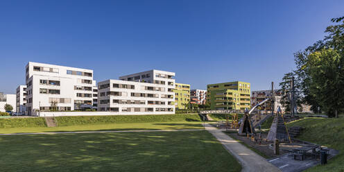 Deutschland, Baden-Württemberg, Ulm, Moderne Vorstadtwohnungen mit öffentlichem Spielplatz im Vordergrund - WDF07021