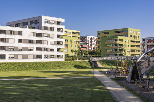 Deutschland, Baden-Württemberg, Ulm, Moderne Vorstadtwohnungen mit öffentlichem Spielplatz im Vordergrund - WDF07022
