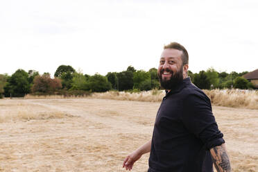 Glücklicher Hipster-Mann auf einem Feld - ASGF02750