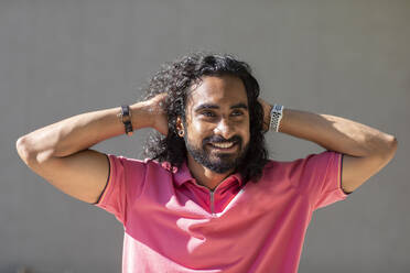 Smiling young man with hands in hair - SGF02916