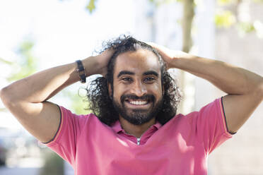 Happy young man with hands in hair - SGF02919