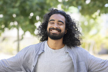 Happy bearded young man with long hair - SGF02924