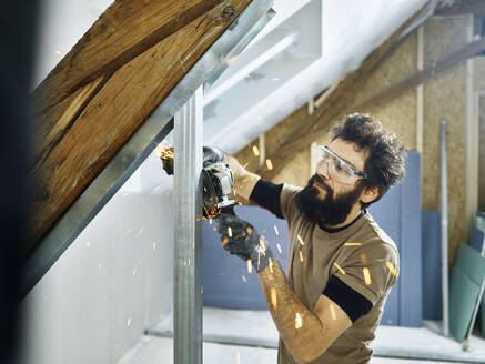 Construction worker cutting metal with grinder at site - CVF02180