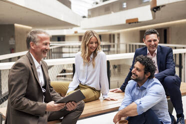 Happy business colleagues planning strategy in office corridor - JOSEF12678