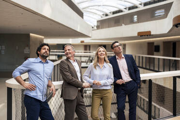 Contemplative business colleagues in office corridor - JOSEF12691