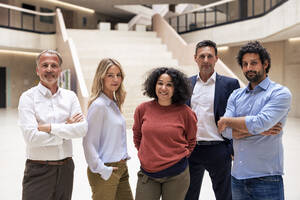 Confident multiracial colleagues standing in lobby - JOSEF12835