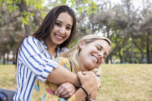 Glückliche junge Frau genießt mit Freund im Park - WPEF06295