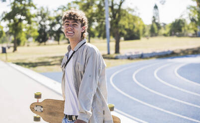 Young man with skateboard on sunny day - UUF27173