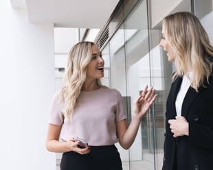 Business people having discussion outside glass wall - AMWF00416