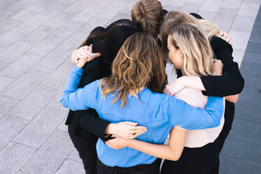 Business people standing in huddle on sunny day - AMWF00423