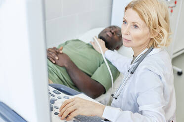 Doctor with blond hair doing ultrasound of patient in clinic - DSHF00549