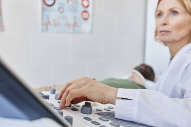 Doctor adjusting ultrasound machine in clinic - DSHF00551